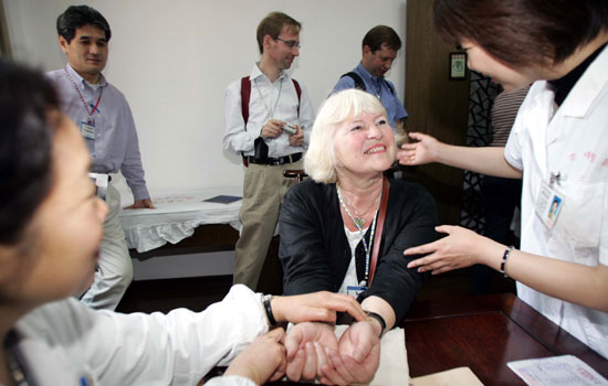 An European woman consulting Chinese doctors at a hospital in Hangzhou, Zhejiang province. China's growing number of expatriates has created an emerging high-end private healthcare business market for insurers at the same time as medical and health insurance are being promoted through the country's medical reform. [Photo/China Daily] 