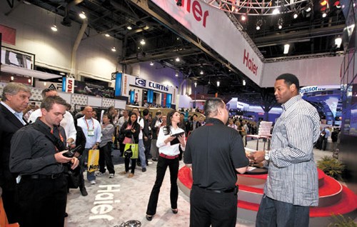 People line up to meet the Los Angeles Lakers star Robery Horry (right) at the Haier stand at 2012 International CES, a consumer electronics trade show in Las Vegas, Nevada. The Chinese appliance maker has hired 350 people in its South Carolina plant. [Ph