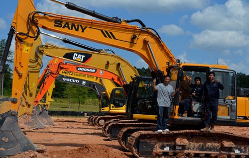 Workers from Sany America demonstrate the company's earth excavator alongside models made by rival manufacturers to potential US clients on the Sany corporate campus in Peachtree City, Georgia. [Photo/ China Daily]