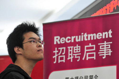 A graduate looks for job during a job fair in Beijing, Oct 11, 2012. [Photo/Xinhua]