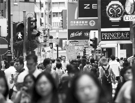 Pedestrians walk past stores on Russell Street in Causeway Bay. Hong Kong is still leading the Asia Pacific region in shopping environment. Jerome Favre / Bloomberg