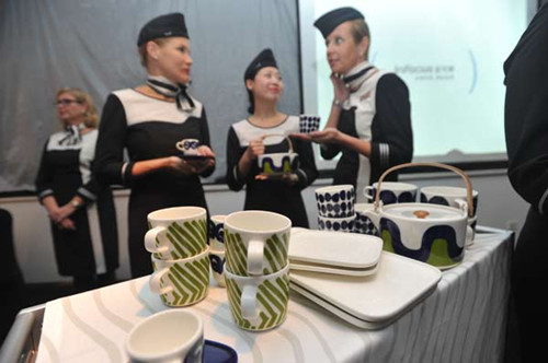 Flight attendants from Finnair were showing the tea sets and coffee cups featuring Marimekko's design in Shanghai, Oct 27, 2012. [Photo/chinadaily.com.cn]