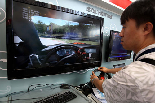 A visitor plays a game at an exhibition hall during the 4th China Cloud Computing Conference in Beijing on May 24. Zhu Xingxin / China Daily