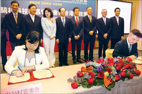 A representative of the Administrative Committee of Zhongguancun Science Park (left) signs an agreement with her counterpart from the Hong Kong Science & Technology Parks. [Photo / China Daily]