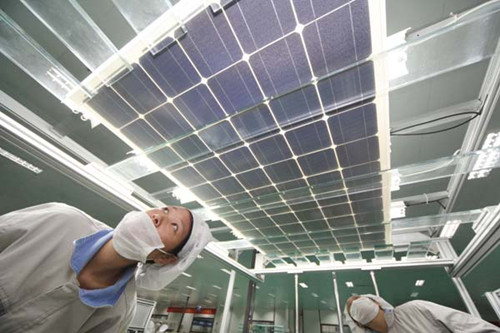 Workers inspect a solar panel at Shanghai Shenzhou New Energy Development Co Ltd's production plant in Lianyungang, Jiangsu province. Si Wei / for China Daily