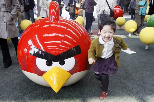 A child poses for a picture at the Angry Birds theme park in Tongji University in Shanghai, on Oct 31, 2012. [Yongkai/Asianewsphoto] 