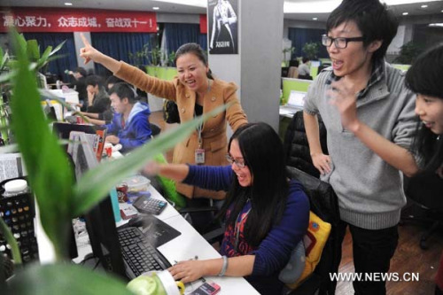 Employees of Qi Gege (literally The Seventh Princess), an online women's wear retailer, celebrate over increased transactions in the company's office during a sales promotion for the November 11 Singles' Day in Hangzhou, capital of east China's Zhejiang Province, early Nov. 11, 2012. (Xinhua/Huang Zongzhi)