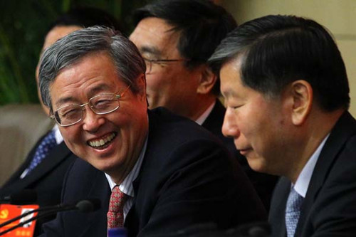 People's Bank of China Governor Zhou Xiaochuan (center) responds to a reporter's question at the media center of the 18th National Congress of Communist Party of China on Sunday. [Zou Hong/China Daily]