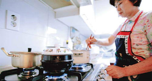 A woman cooking food at home. International electrical appliance producers, including Emerson Electric Co of the United States and Dyson of the United Kingdom, see the demand for food waste disposal units in China will be very attractive in coming years. [Photo/China Daily] 