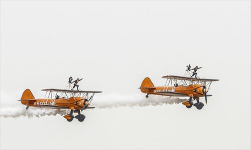 Female acrobats strike a pose atop biplanes during a rehearsal on the eve of the ninth China International Aviation and Aerospace Exhibition in Zhuhai on Monday. The exhibition takes place from November 13 to 18. Photo: AFP 