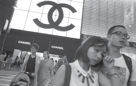 Pedestrians cross the road in front of a Chanel store in Tsim Sha Tsui. Hong Kong will still keep its position as the best shopping destination in the coming years, according to Jones Lang LaSalle. [Photo/Agencies]