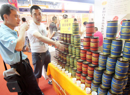 An attendee of a trade show in Beijing in June tries a sample of Brazilian instant coffee. [Photo/China Daily] 