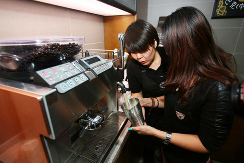 A customer learns to make coffee under the instruction of a Starbucks employee at the Starbucks China University in Beijing, Nov 26, 2012. [Photo/chinadaily.com.cn]