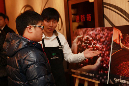 A Starbucks barista introduces coffee culture to a customer at the Starbucks China University in Beijing, Nov 26, 2012. [Photo/chinadaily.com.cn] 