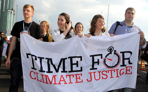Activists carry placards during a rally in Doha on Saturday to demand urgent action addressing climate change as the United Nations Convention on Climate Change continues in the Qatari capital. The chances of hitting the UN's global warming target are diminishing, but the goal can still be met if greenhouse gas emissions fall by 15 percent by 2020, scientists said. [Photo/Agencies]