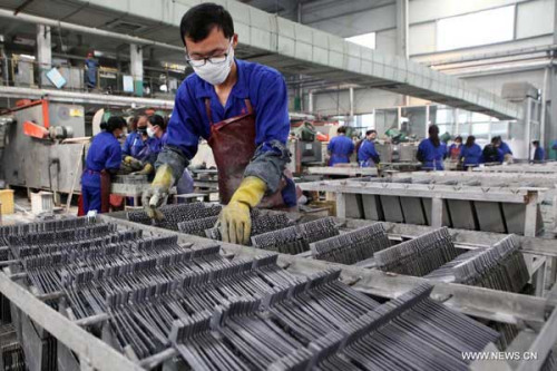 Workers produce battery lead plate at a company in Ganyu County, east China's Jiangsu Province, Oct. 31, 2012.  (Xinhua/Si Wei)