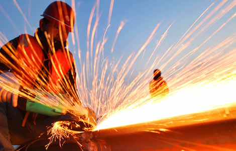A worker welds at a construction site in Lianyungang, Jiangsu province, Dec. 3, 2012. [Photo by Si Wei/Asianewsphoto]