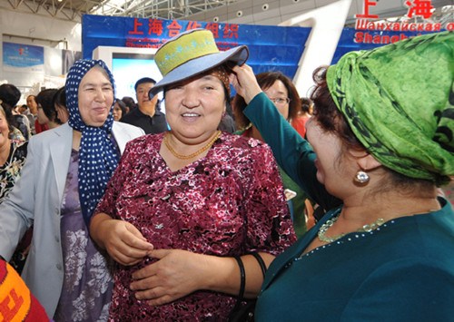 A Uygur woman tries on a hat made in Kyrgyzstan at the First China-Eurasia Expo held in Urumqi, the Xinjiang Uygur autonomous region, in September 2011. [Photo/Xinhua]