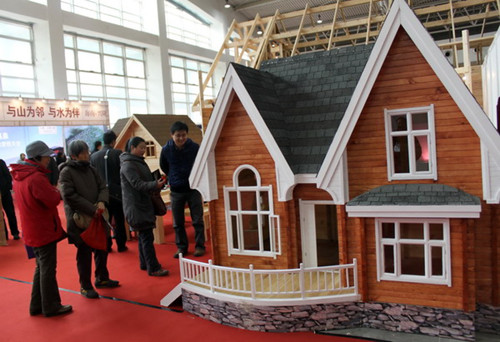Visitors look at a villa model at a luxury housing expo in Beijing, March 3, 2012. [Liu Huaiyu/Asianewsphoto]