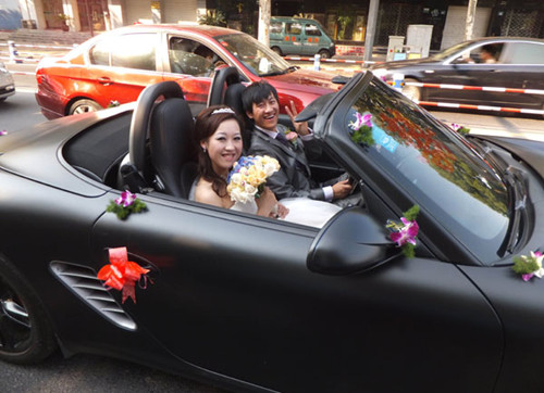 A newly married couple in a luxury car. The most favorite purchases of rich Chinese tend to be leather goods and automobiles, according to the latest report by Robb and Ipsos, which said the top two products accounted for about 20 percent of Chinese millionaires' total consumption over the past year. [Wang Zhicheng / For China Daily]