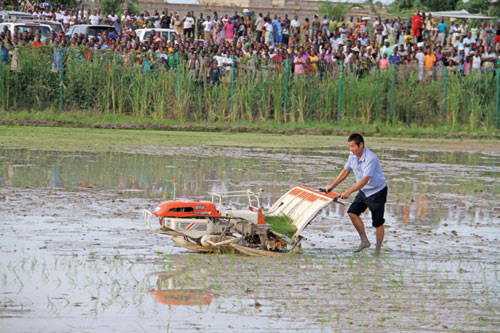 A Chinese expert demonstrates the use of a rice transplanter. China has dispatched nearly 10,000 agricultural technicians to Africa since the 1950s. LU RONG / XINHUA 