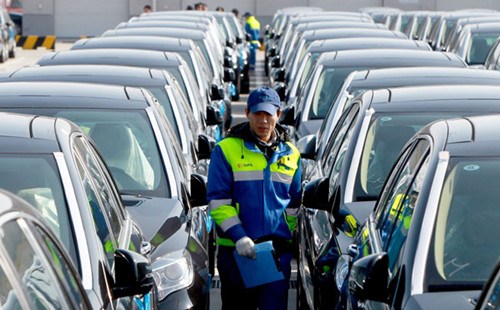 An inspector walks among imported vehicles at Shanghais Waigaoqiao port. China imported 79,800 vehicles in November, down 26.1 percent year-on-year. PEI XIN / XINHUA