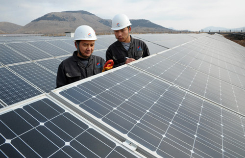 Workers from a solar manufacturing company in Shandong province check solar panels on Wednesday. [PHOTO BY LI ZONGXIAN / FOR CHINA DAILY]