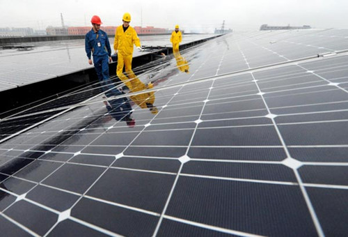 Technicians supervise the solar panels on the roof of a building in Shaoxing, East China's Zhejiang province, Dec 27, 2012. [Photo/Xinhua]