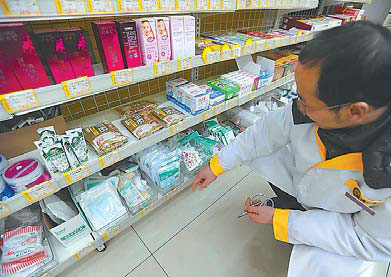 A salesman checks masks on a shelf at a drugstore in Chengdu, capital of Sichuan province, on Monday. Sales of masks remained at normal levels even though smog had shrouded the city for days. The city is located in a basin where haze is a constant visitor, especially in winter. Yu Ping / China Daily