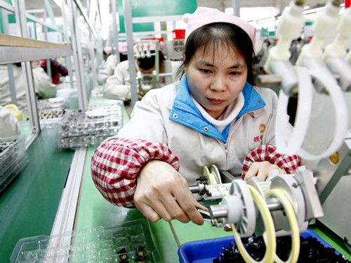 A woman works in a factory in her hometown in Huaying, Sichuan province, on Jan 22. After returning home for Spring Festival, the former migrant worker found a job closer to home. [ZHOU SONGLIN / FOR CHINA DAILY]