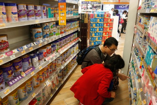 A couple looks at baby formula in a shop in Hong Kong on Friday. [Photo: China Daily/ Vincent Yu]