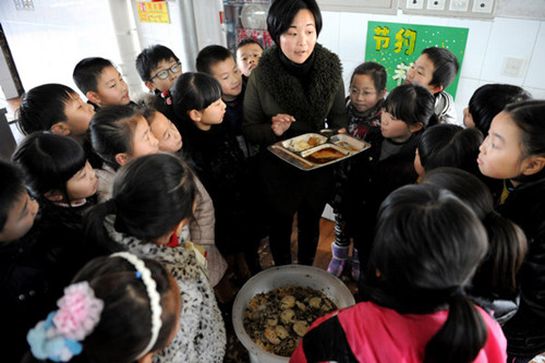 A teacher highlights the problem of food waste at Qunxing School, Yiwu, Zhejiang province, last month. [ZHANG JIANCHENG / FOR CHINA DAILY]