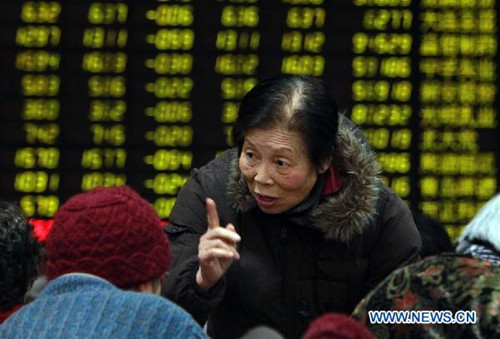 An investor talks with other people at a securities trading center in east China's Shanghai, Feb. 19, 2013. Chinese stocks closed lower on Tuesday. The benchmark Shanghai Composite Index closed at 2,382.91 points, down 1.61 percent, or 38.64 points. The Shenzhen Component Index dropped 2.50 percent, or 244.98 points, to end at 9,550.93. (Xinhua/Ding Ting)