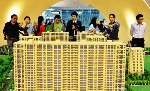 Potential homebuyers check property prices at a real estate fair in Hangzhou, Zhejiang province. Long Wei / for China Daily 