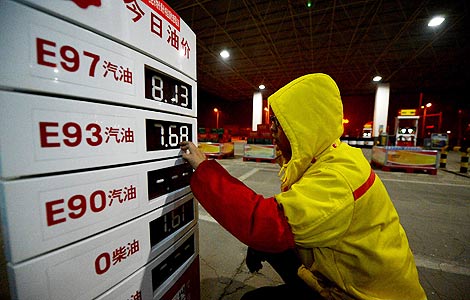 A worker changes the gasoline prices displayed on a signboard at a gas station in Hefei, East China's Anhui province, Feb 25, 2013. [Photo/Xinhua]