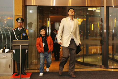 Retired basketball player Yao Ming, a CPPCC member, frowns at the smog as he leaves a hotel in Beijing on Thursday morning. [Liu Guanguan/China News Service]