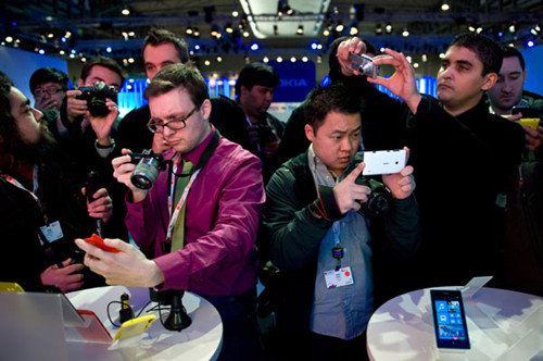 Visitors taking pictures of new Nokia devices during the Mobile World Congress 2013 in Barcelona, Spain, in February. Across the world, Nokia remains the No 1 Windows Phone vendor, with a market share of 78 percent last year. [Photo/China Daily]