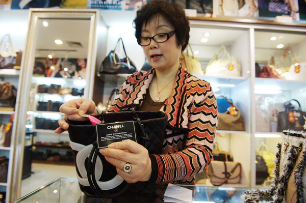 A shopkeeper selling secondhand luxury items at a department store in Beijing. The deputy chief of the National Tourism Administration has urged the government to introduce price controls on imported luxury goods. [Photo / China Daily] 