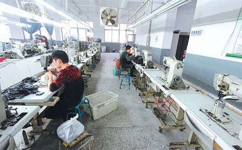 Most machines remain idle after Spring Festival due to a shortage of workers at a shoe-making factory in Jinjiang, Fujian province. Companies expect employee levels to increase in the second quarter of the year in six industries surveyed. [Photo/China Daily]