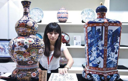 A worker arranges a Japanese porcelain exhibit at a trade fair in Beijing. China, Japan and South Korea are pushing for progress on trilateral free trade agreement talks, according to a Japanese trade official. [Photo/China Daily]