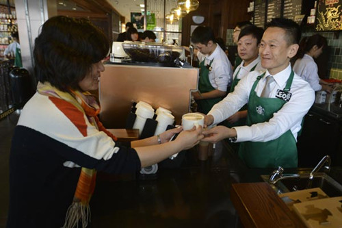 A customer receives her order at a Starbucks coffee shop in Taiyuan, Shanxi province. [Photo/China Daily]