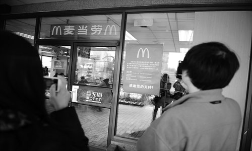 Two customers take photos of Beijing's second-oldest McDonald's restaurant in Xicheng district Thursday. The restaurant will be closed on March 24. Photo: Li Hao/GT