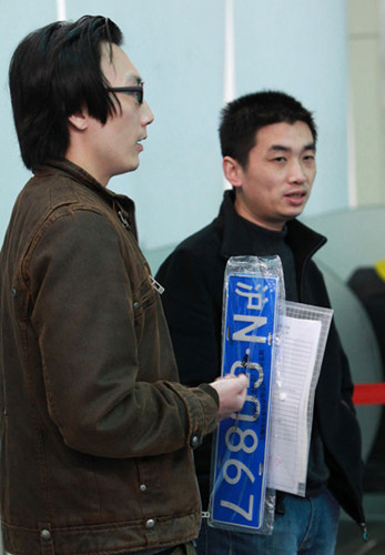 A Shanghai resident registers his license plate at the city's vehicle management bureau on Saturday. PEI XIN/XINHUA