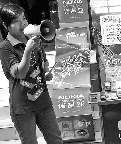 Using a megaphone, a woman promotes sales of Nokia cellphones in front of a mobile phone store in Yichang in Central China's Hubei province. Nokia Siemens was the first foreign vendor of telecoms equipment to gain approval from the Chinese authorities to participate in the country's wide-ranging trials of TD-LTE starting from 2011. [Photo/China Daily]