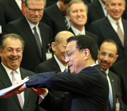Premier Li Keqiang explains his late arrival to a meeting of business leaders of major companies who attended the China Development Forum on Monday at the Great Hall of the People in Beijing. Wu Zhiyi/china daily