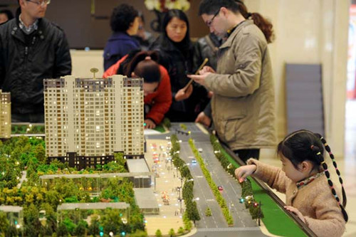 Property buyers look at real estate models in Hangzhou, Zhejiang province. According to a report by Forbes China, 96.7 percent of the Chinese middle class own apartments. [Photo/China Daily]