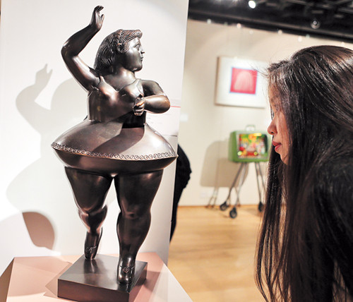 A woman examines a piece at Boundless: Contemporary Art in Hong Kong, Sotheby's first auction of Asian and Western contemporary art in Asia, in December. [Photo/Xinhua]