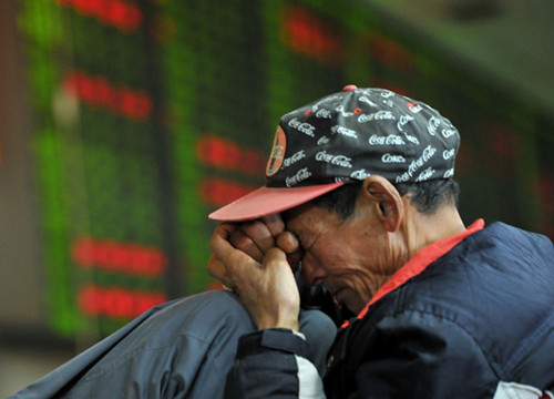 A man at a brokerage in Nanjing, Jiangsu province. The Shanghai Composite Index closed at 2,211.59 on Monday, down by 0.62 percent. Liu Yifan/For China Daily