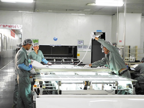 Workers assemble solar panels at Wuxi Suntech, which defaulted on a $541 million bond repayment in March, in Jiangsu province. Experts say that a possible acquisition by Warren Buffett is very likely due to the billionaire's investment habits and would be a win-win situation. [Provided to China Daily]