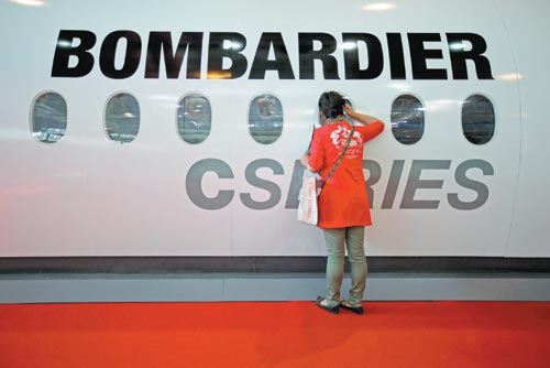 A visitor examines a Bombardier jet model at an expo in Zhuhai, Guangdong province. China had 336 registered business jets as of 2012, with Shanghai's airports accounting for a third of the nation's total business flights. [Provided to China Daily]